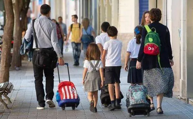 Stock image of parents taking their children to school.