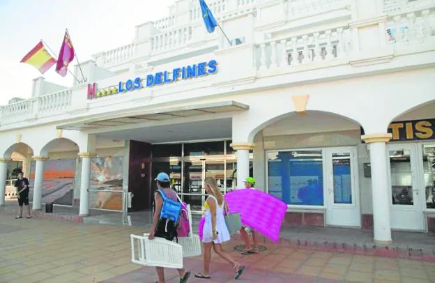 Turistas pasan por delante del hotel Los Delfines, perteneciente a Grupo Hotelania, ayer en La Manga. / ANTONIO GIL / AGM