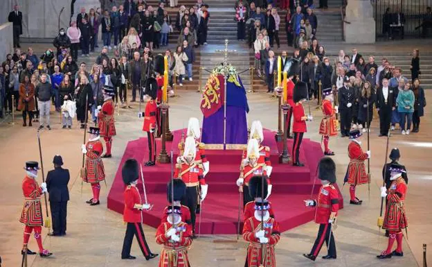 The royal guards guard the coffin of Isabel II while thousands of people line up to say goodbye to the deceased.