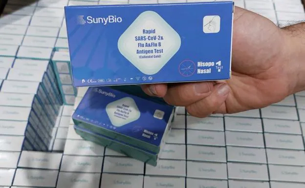 A pharmacist shows the tests for covid and flu that can already be bought in pharmacies in the Region of Murcia. 