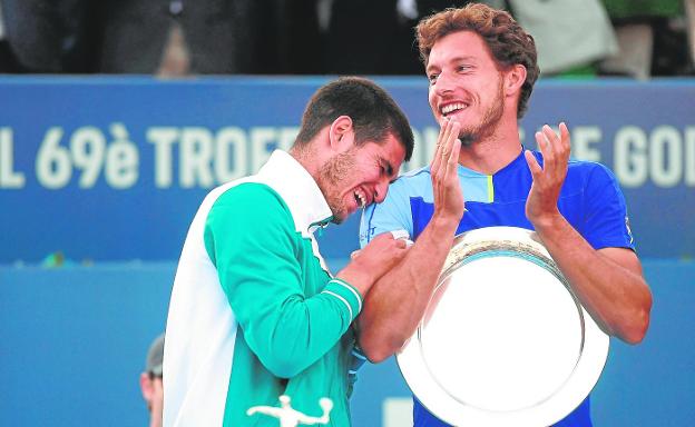 Carlos Alcaraz and Pablo Carrero joke at the Godó trophy delivery ceremony in April. 