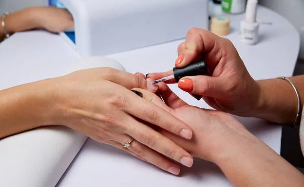 In a nail salon they apply a permanent nail polish.