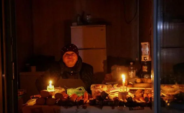 A vendor lights her stall with candles on a street in Odessa.