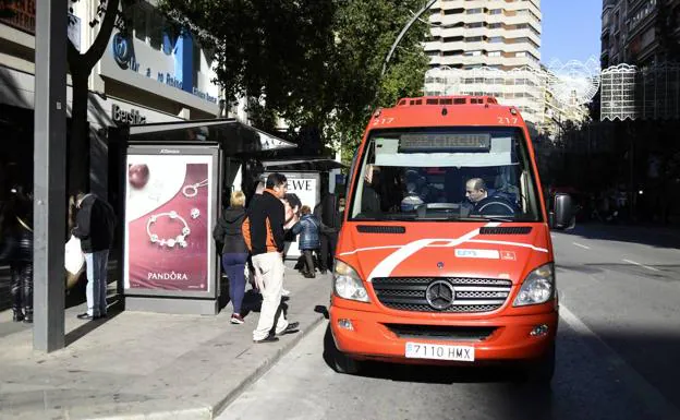 An urban bus picks up several passengers on the Gran Vía in Murcia. 