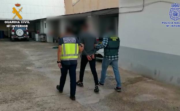 Agents of the National Police and the Civil Guard, with one of the detainees.