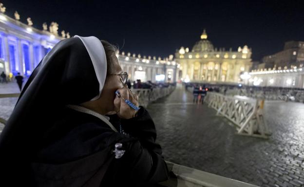A nun prays in front of St. Peter's Basilica in the Vatican. 
