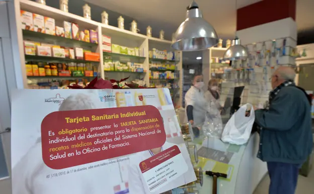 A sign in a pharmacy in Murcia reminds that it is mandatory to present the health card to pick up prescription drugs. 